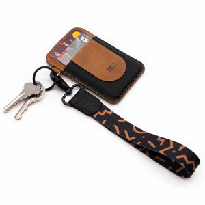 black brown hand wrist lanyard with keys and brown leather slim wallet